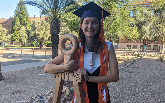 Graduate posing with Bent statue.