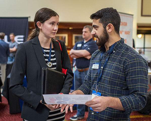 Female student speaking to recruiter at a recruiting fair.